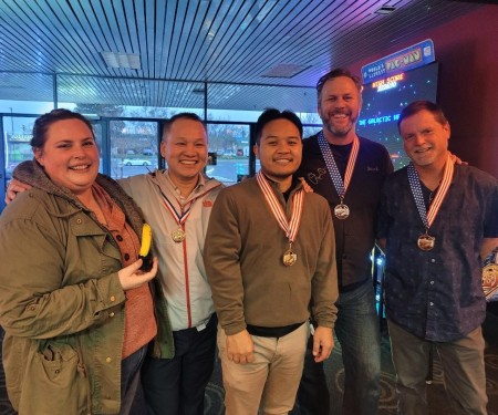 Members from IT Implementations team pose for a group photo with their bowling trophies